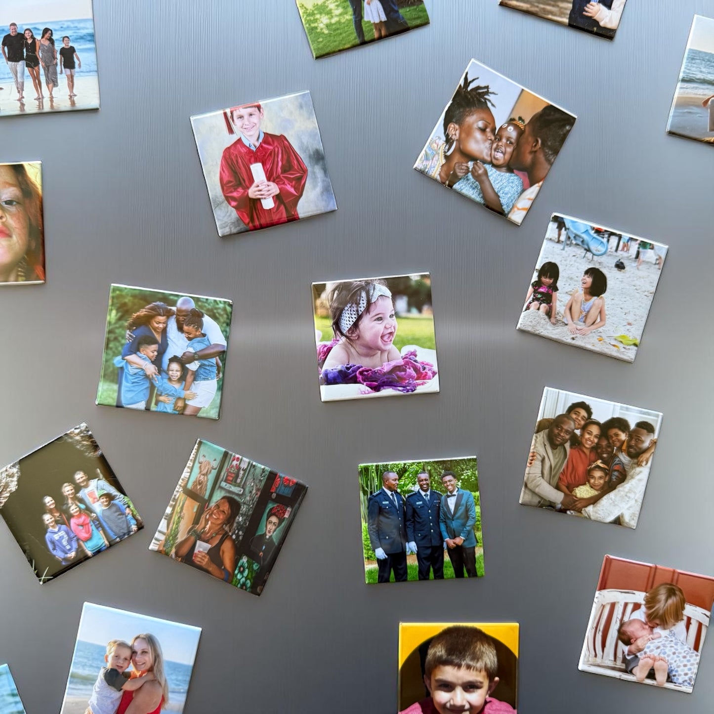 Collection of square photo magnets of various images on a gray background
