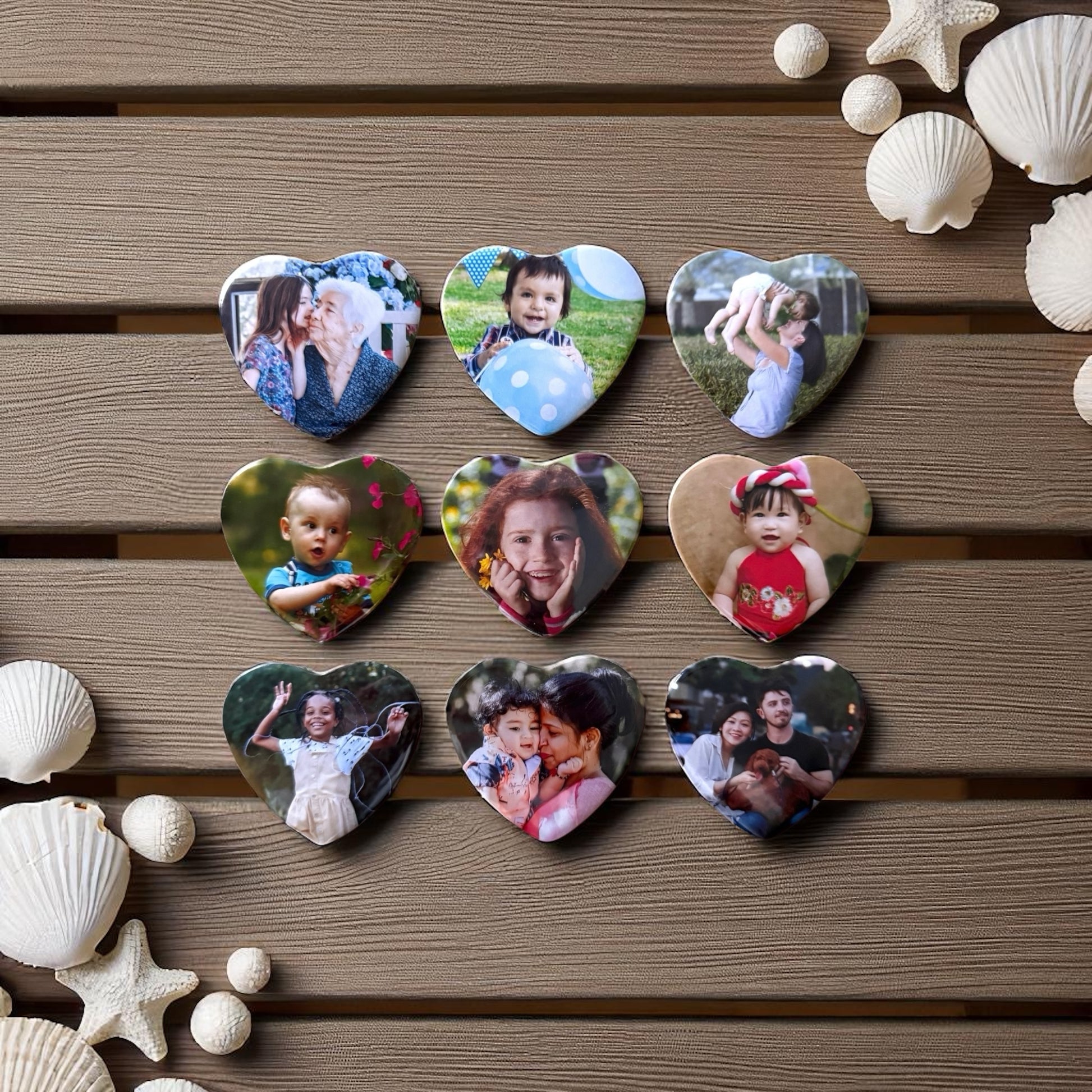 Collection of heart-shaped photo magnets with various images on a wooden surface with seashells and starfish.