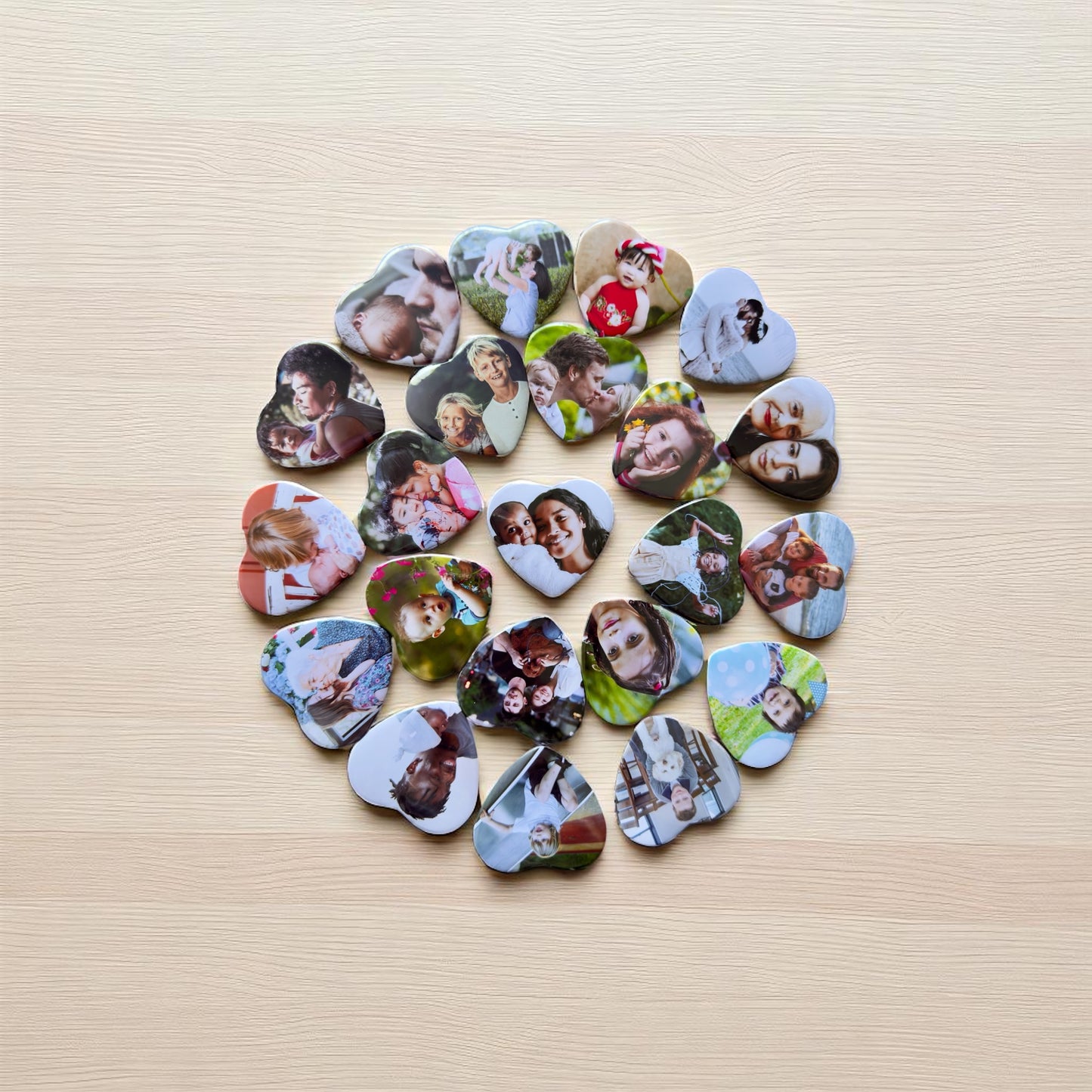 Heart-shaped photo magnets arranged in a circular pattern on a wooden surface