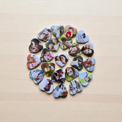 Heart-shaped photo magnets arranged in a circular pattern on a wooden surface